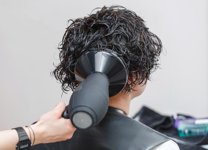 Stylist drying hair with a hair dryer with a diffuser