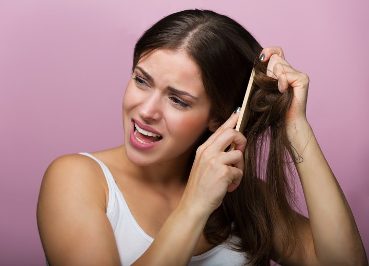 Girl feeling pain when combing her hair