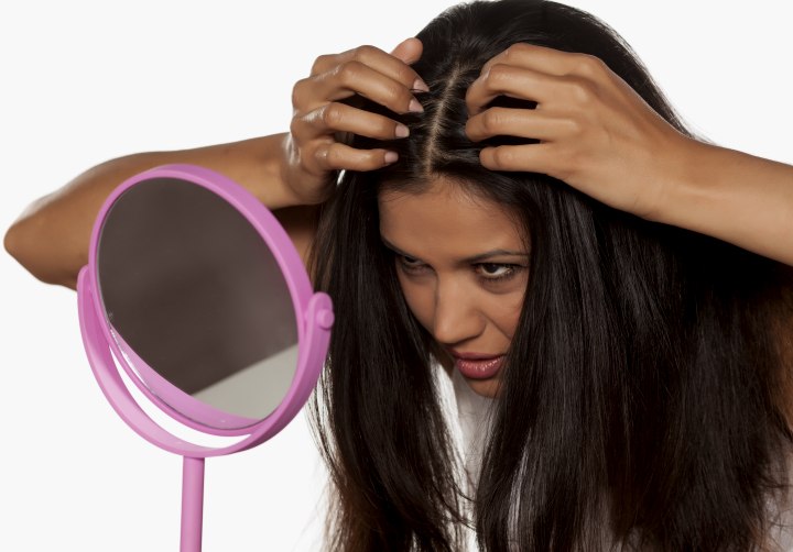 Woman checking the roots of her hair for new growth