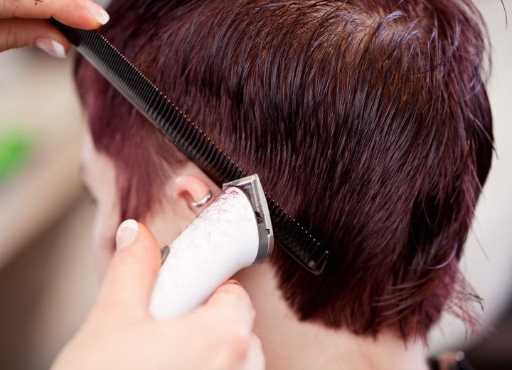 Hair stylist doing clippes over comb hair cutting