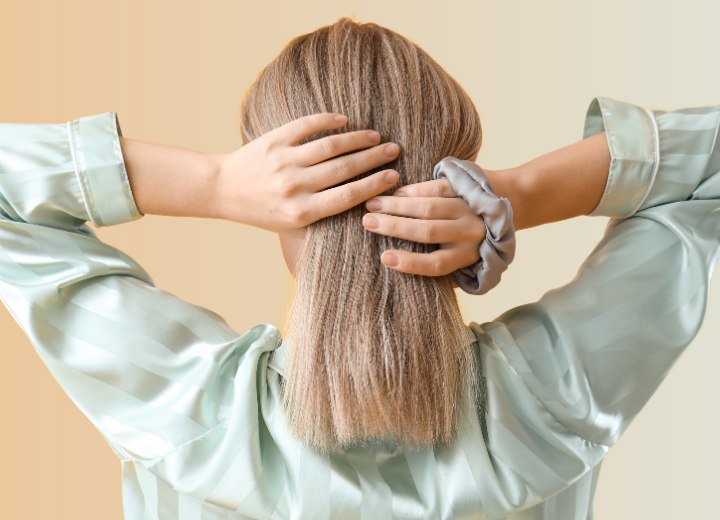 Woman tying her hair up with a silk scrunchie