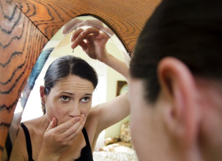 Woman plucking a gray hair