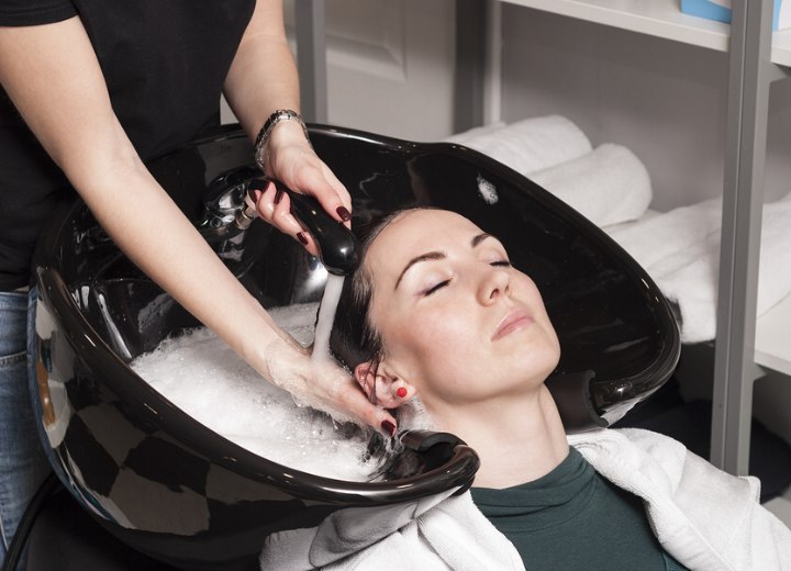 Salon assistant washing hair