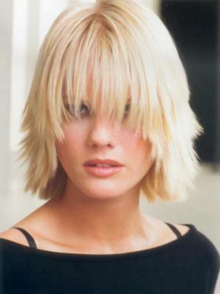 Medium hairstyle with chunky layers and a curved fringe
