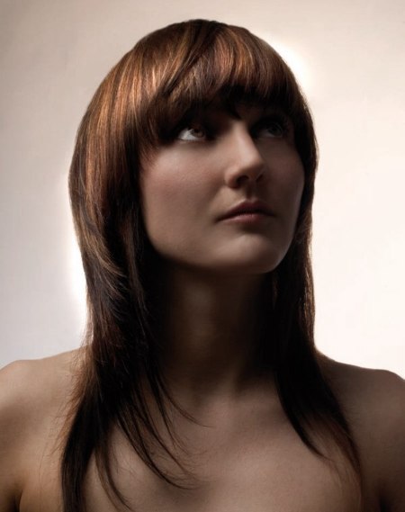 Long layered haircut with full bangs and wispy ends