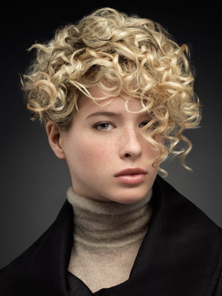 Short blonde hairstyle with curls that cover the forehead