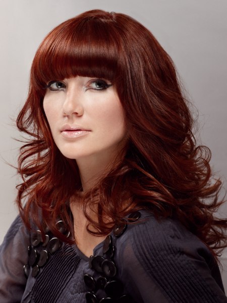 Long layered red hair with curls and a low above the eyes fringe