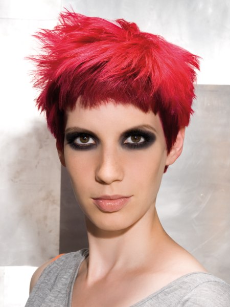 Short punky haircut with raspberry pink coloring and a minimalist fringe