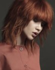 Copper red hair cut into a long layered bob with thick bangs