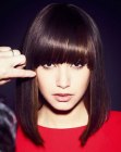 Sleek shoulder length hairdo with angled bangs