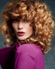 Voluminous hairstyle with hand-tousled curls and bangs