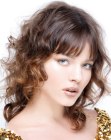 Soft brown hairstyle with curls and straight bangs