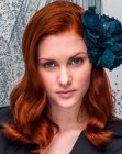 Hairstyle with a flower for long red hair