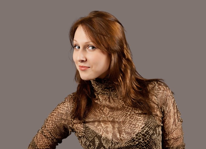 Woman with caramel brown hair wearing a high necked sheer blouse