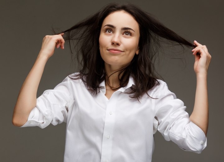 Woman who is checking her own hair for dirt