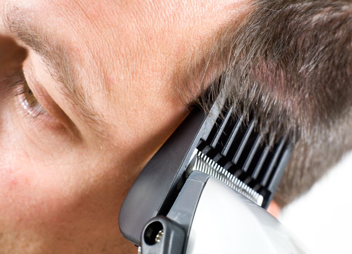 Man who is getting his hair cut with clippers