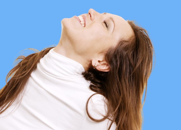 Mujer joven disfrutando del tacto de su cabello