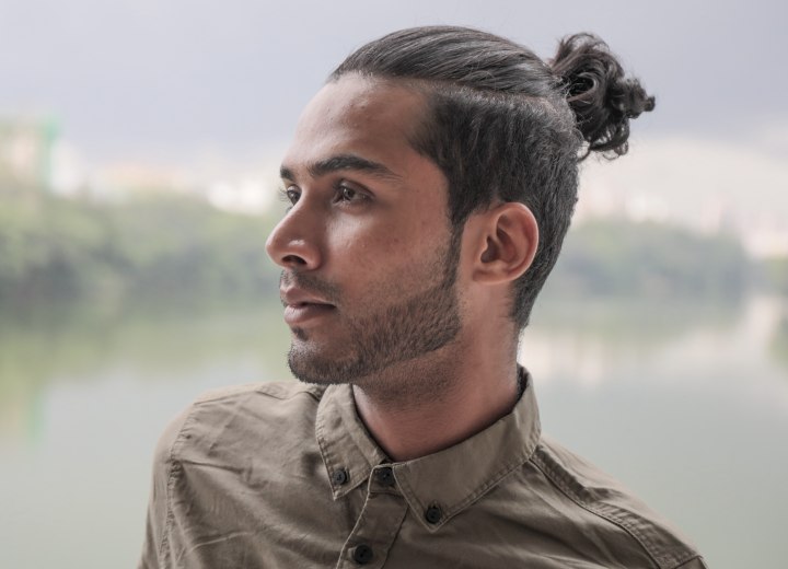 Man with his hair in a short ponytail