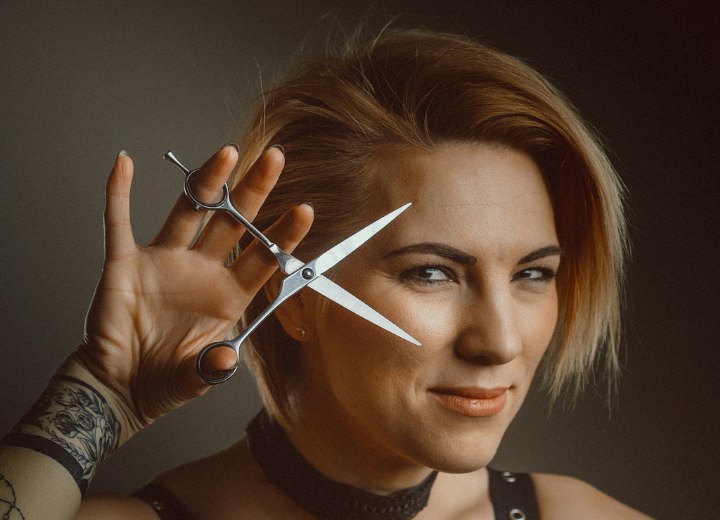 Motivated hairdresser holding scissors