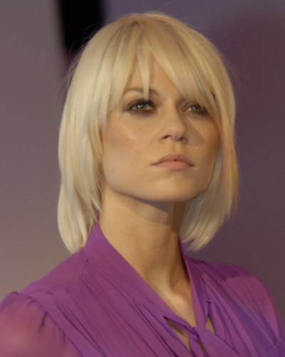 Platinum blonde hair cut below the collar and with angles 