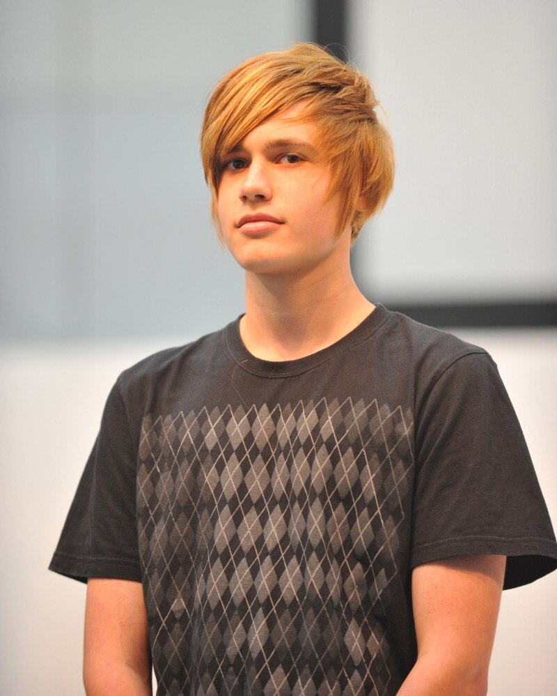 Young man with short blonde hair and forward swept strands 