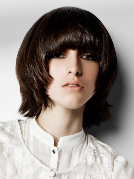 Medium length hair with bangs styled into the face