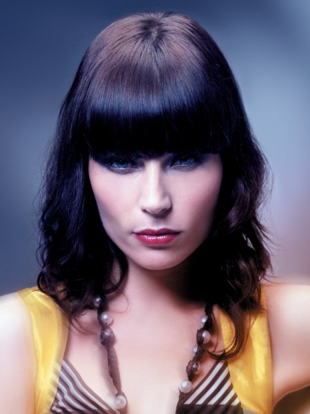Medium hairstyle with blunt bangs and spiral curls along the face