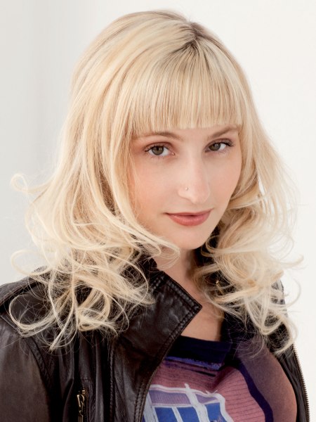 Long blonde hairstyle with curls and straight bangs