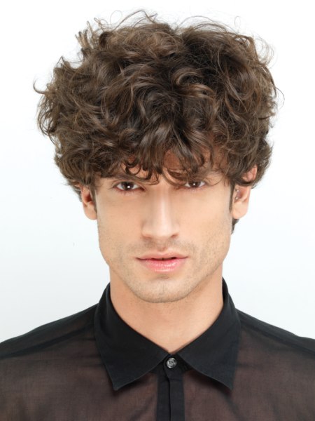 Hair with curls and a low sitting fringe for men