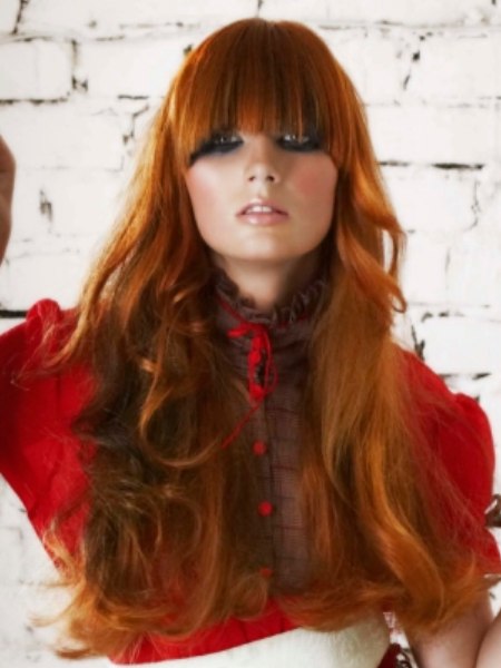 Trendy long red hairstyle with waves and curls