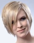 Short razor cut hair with a side part and long textured bangs