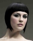 Black concave bob haircut with blunt bangs and sleek styling