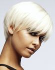 Feathery short hairstyle with eye-long bangs and a soft neckline