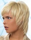 Sporty short haircut with tapered hair along the sides and short bangs