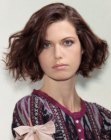 Sporty short hair with a triangular shape and a side parting
