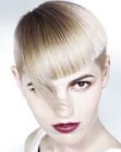 Short blonde bowl cut hair with tilted bangs