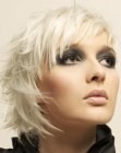 Short and feathery platinum blonde hair with asymmetrical bangs