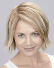 Blonde bob haircut, styled with an outward flip