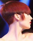 Short red hair with a buzzed nape and full bangs