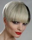 Short bowl shape haircut for blonde hair with a black streak