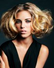 Short blonde hairstyle with big curls and volume