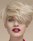 Blonde pixie cut with overlapping layers and styling towards the front