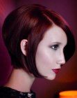 Straight and shiny short red hair with a long strand curved into the face