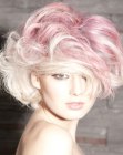 Short blonde hair with large waves and pink color accents