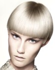 Bowl style haircut with a dominant fringe and sleek styling