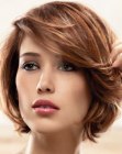 Layered short bob hairstyle with hair ends that curve inward