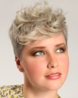 Women's haircut with a clipper cut back and a curly front