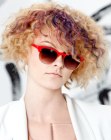 Short blonde hair with spiral curls and purple strands