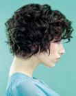 Wedge inspired haircut for shiny black hair with curls