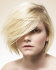 Modern blonde bob with bangs that fall over the eyes